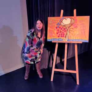 Jasmijn toont het schilderij Hart van de wereld in het theater